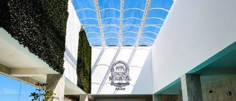 Una piscina con techo de cristal, un cartel que dice 'DON MIGUEL' y vistas al cielo.
