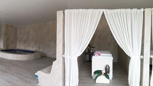 Un baño moderno con una bañera independiente, zona de ducha y tocador con un jarrón y flores.