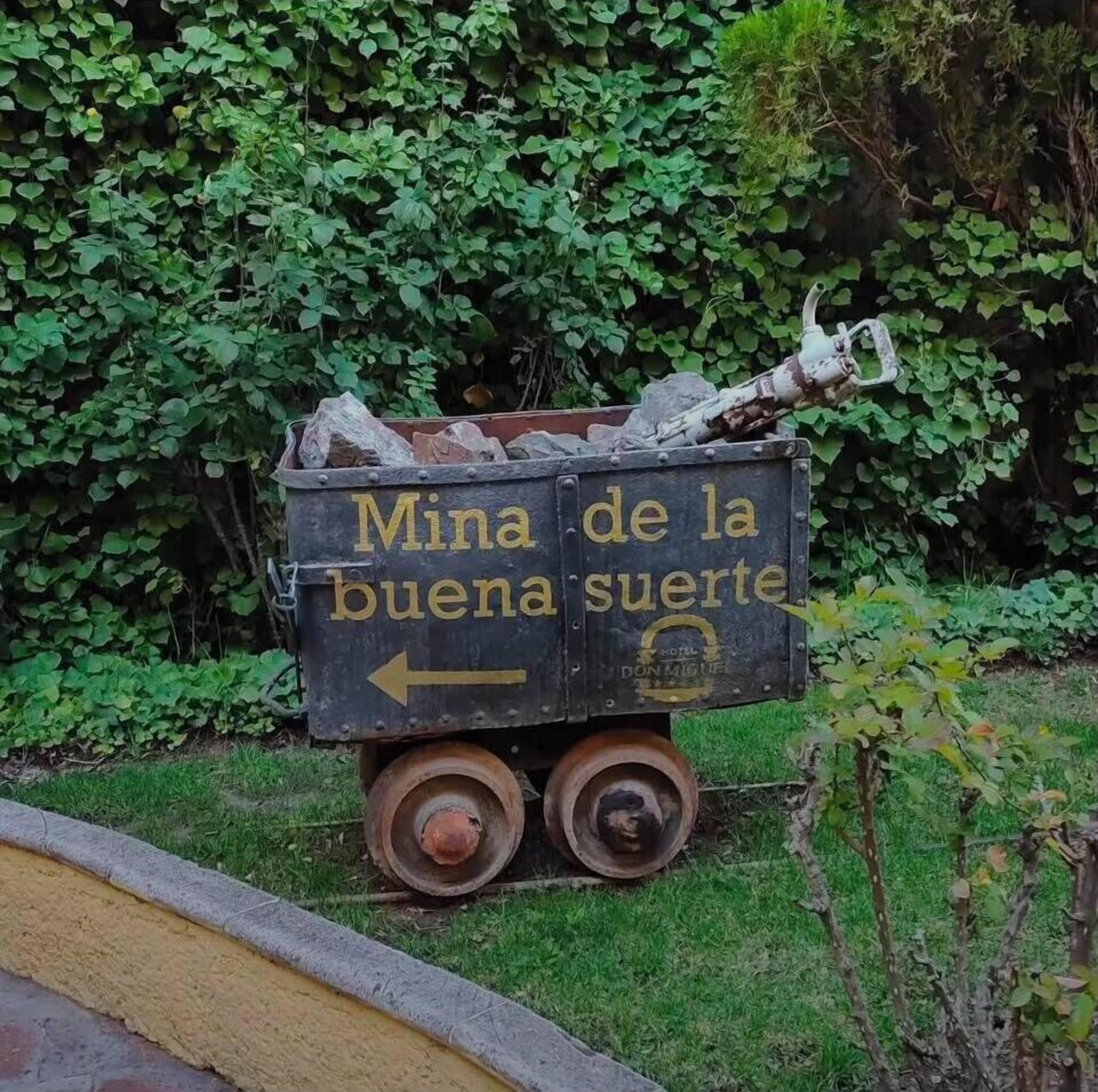 A dumpster with the text 'Mina de la buena suerte' and an arrow pointing left.