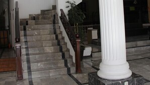A marble staircase with a white column and a potted plant. - Hotel María Benita (Zacatecas)