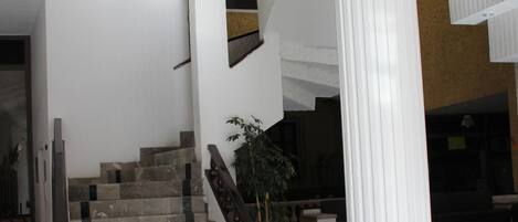 A marble staircase with a white column and a potted plant.