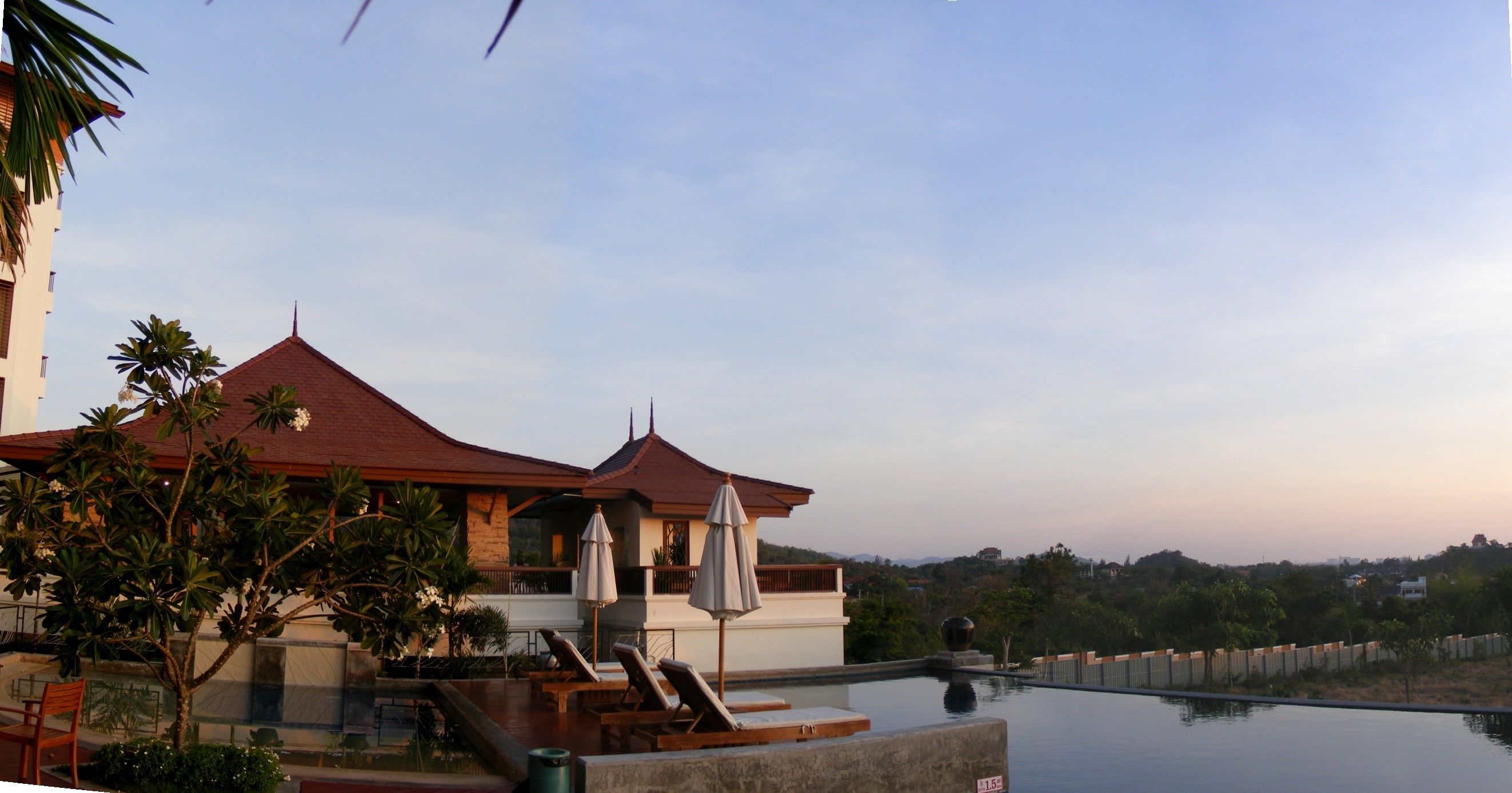 Een buitenzwembad, ligstoelen bij het zwembad