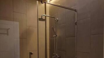 A modern bathroom with a skylight, glass shower enclosure, and a white toilet.