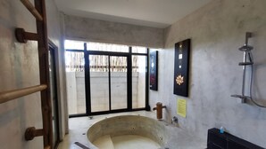 A bathroom with a freestanding bathtub, a wooden ladder, a shower, and a window with a view of a fence. - Amara Resort Hua Hin (Hua Hin)
