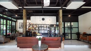 A modern lobby with a reception desk, seating area, and a bar. - Amara Resort Hua Hin (Hua Hin)