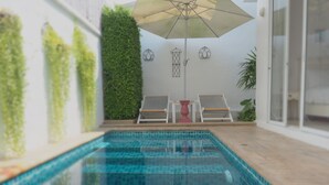 A swimming pool with tiled flooring, a ceiling fan, and a potted plant. - Costa Village Pool Villa (Pattaya)