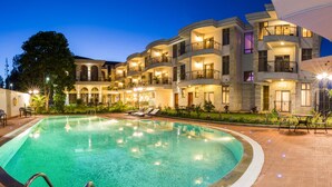 A hotel with a swimming pool, multiple balconies, and outdoor seating areas. - Alba Hotel Meru (Meru)