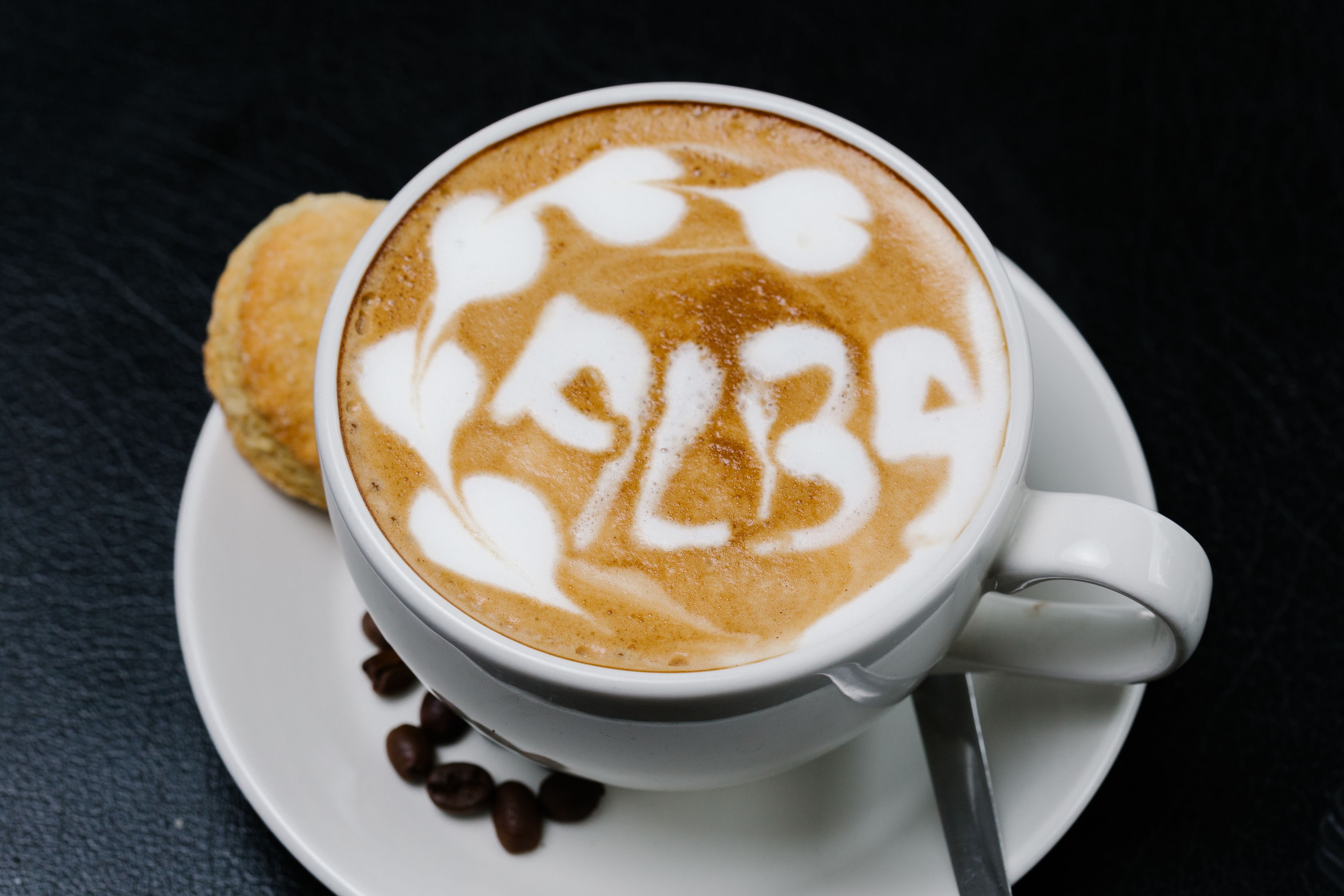 Une tasse de café avec un motif en latte sur une soucoupe.