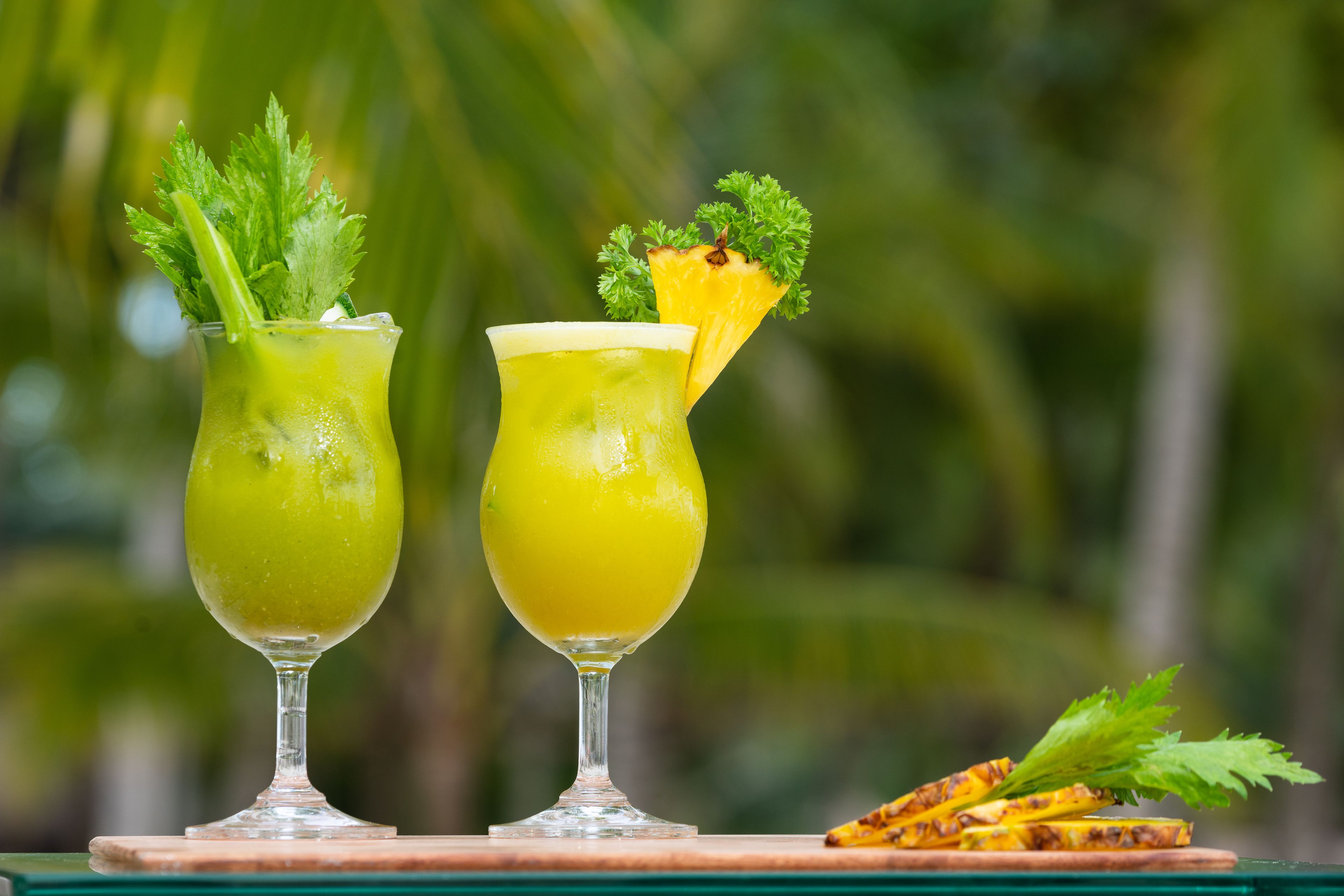 Twee drankjes met garnering op een houten ondergrond.