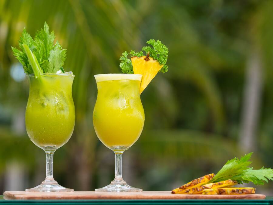 Twee drankjes met garnering op een houten ondergrond.