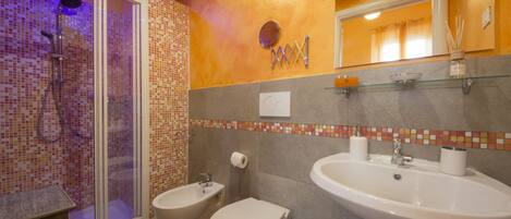 Un baño con ducha, bidé, inodoro y lavabo.