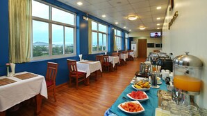 A dining area with tables, chairs, and a buffet with food and beverages. - 79 Living Hotel (Mandalay)
