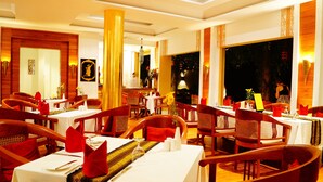 A restaurant with multiple tables, wooden chairs, and a warm ambiance. - Areindmar Hotel (Nyaung-U)