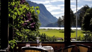 A table set for two with a view of a lake and mountains. - Dalen Hotel (Tokke)