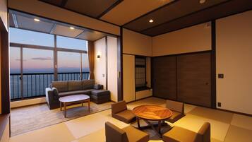A modern living room with a sofa, a coffee table, and a view of the sea.