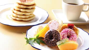 A breakfast setting with pancakes, a cup of coffee, and assorted pastries.