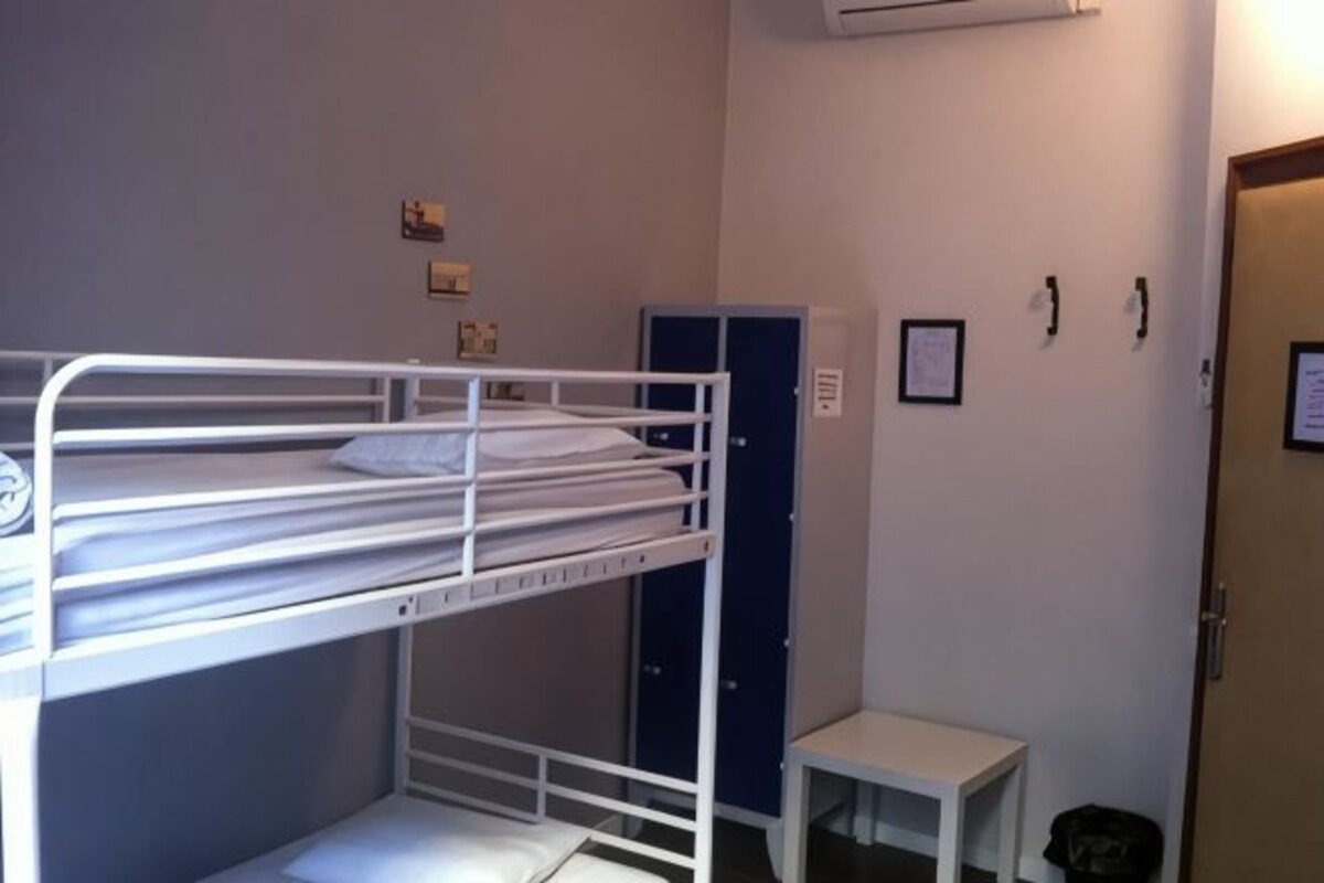 A bunk bed room with a small table and a door.