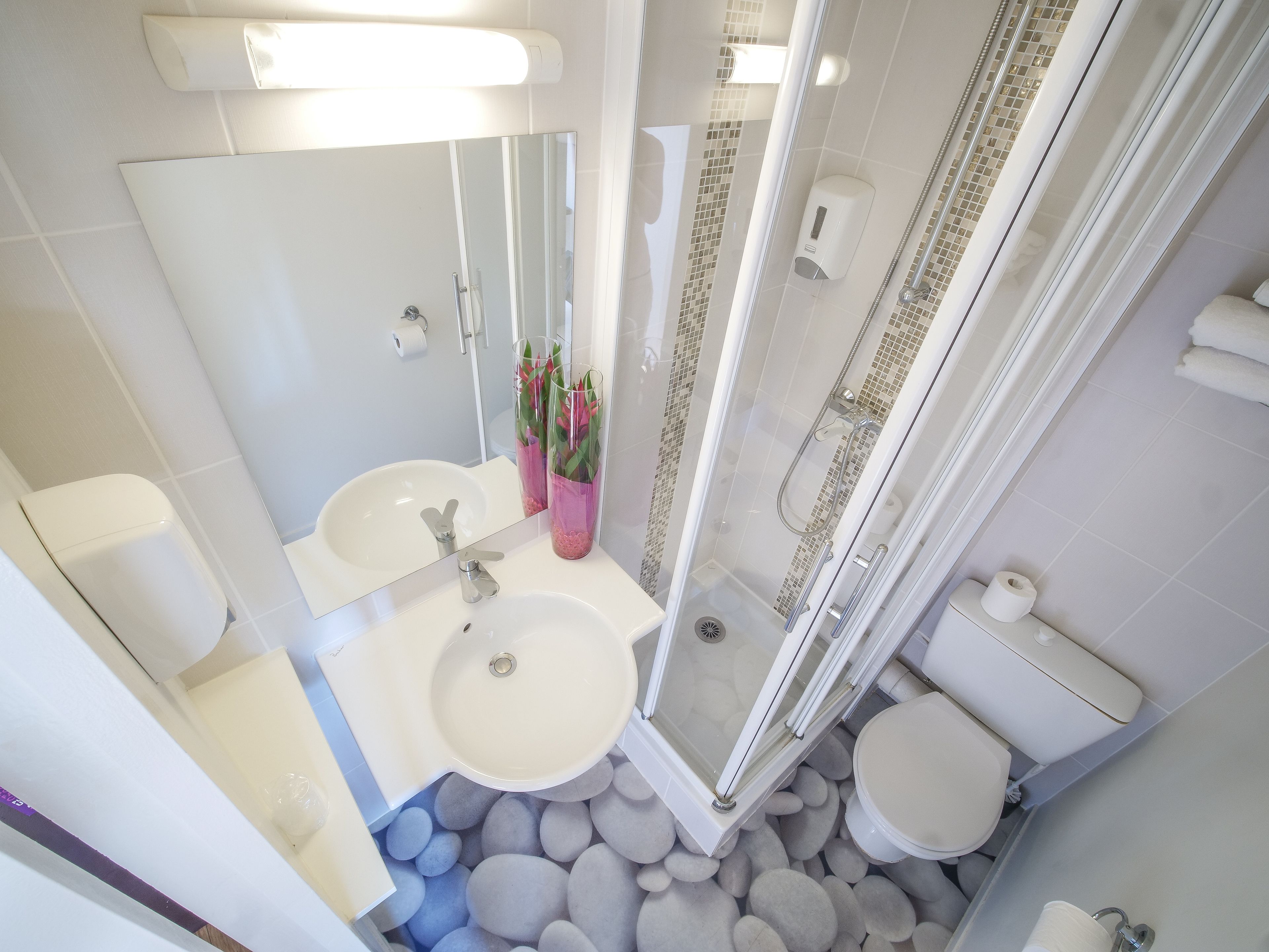 Un baño con dos lavamanos, inodoro, ducha y espejo.