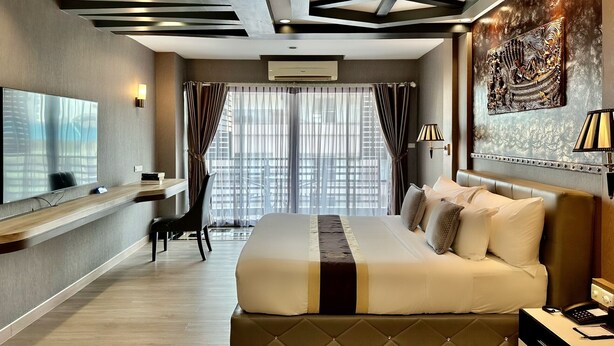 A modern hotel room with a large bed, a desk, and a television. - KTK Pattaya Hotel and Residence (Pattaya)