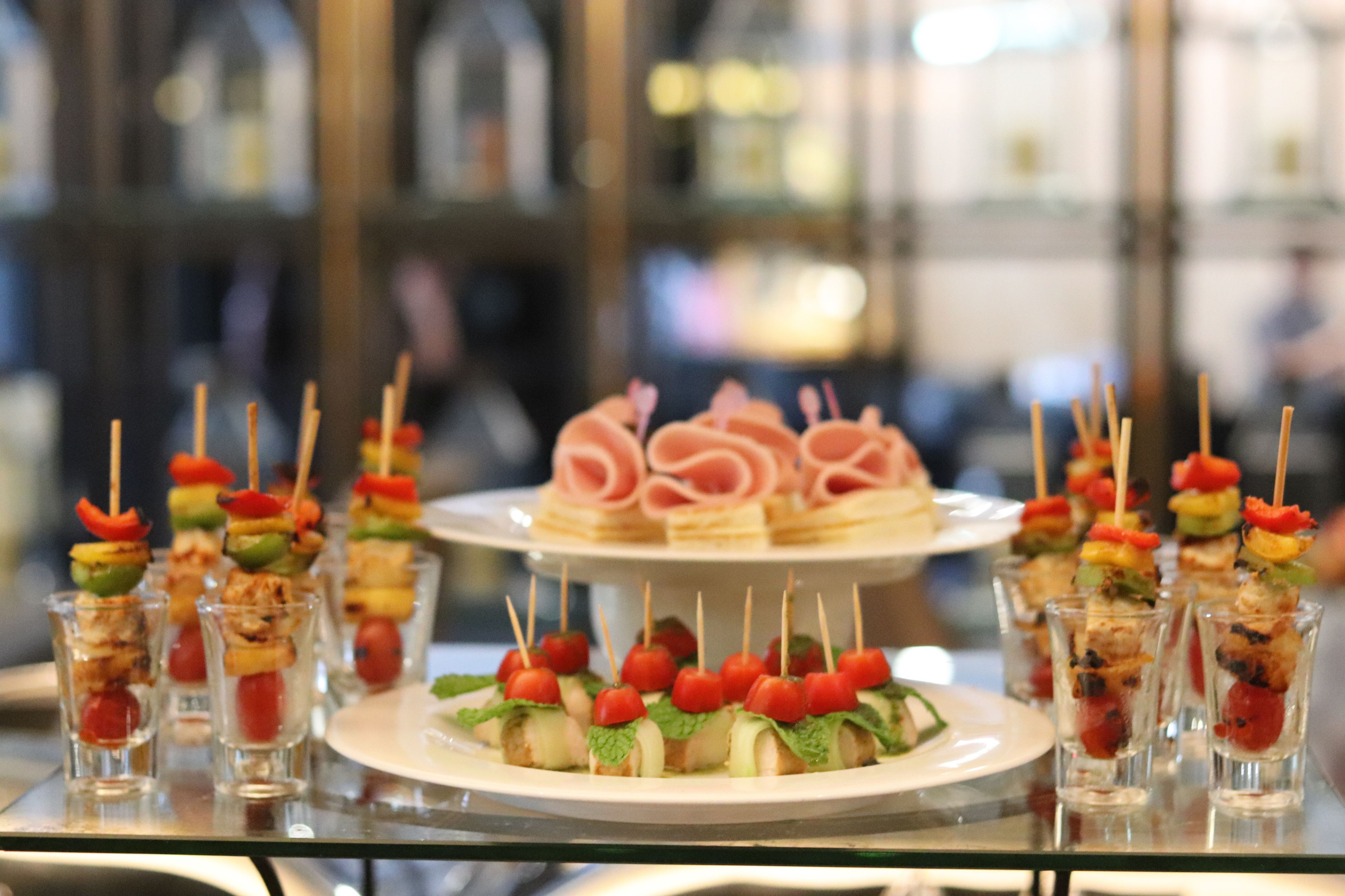 Une table de buffet proposant divers plats, notamment des brochettes et des amuse-gueules.