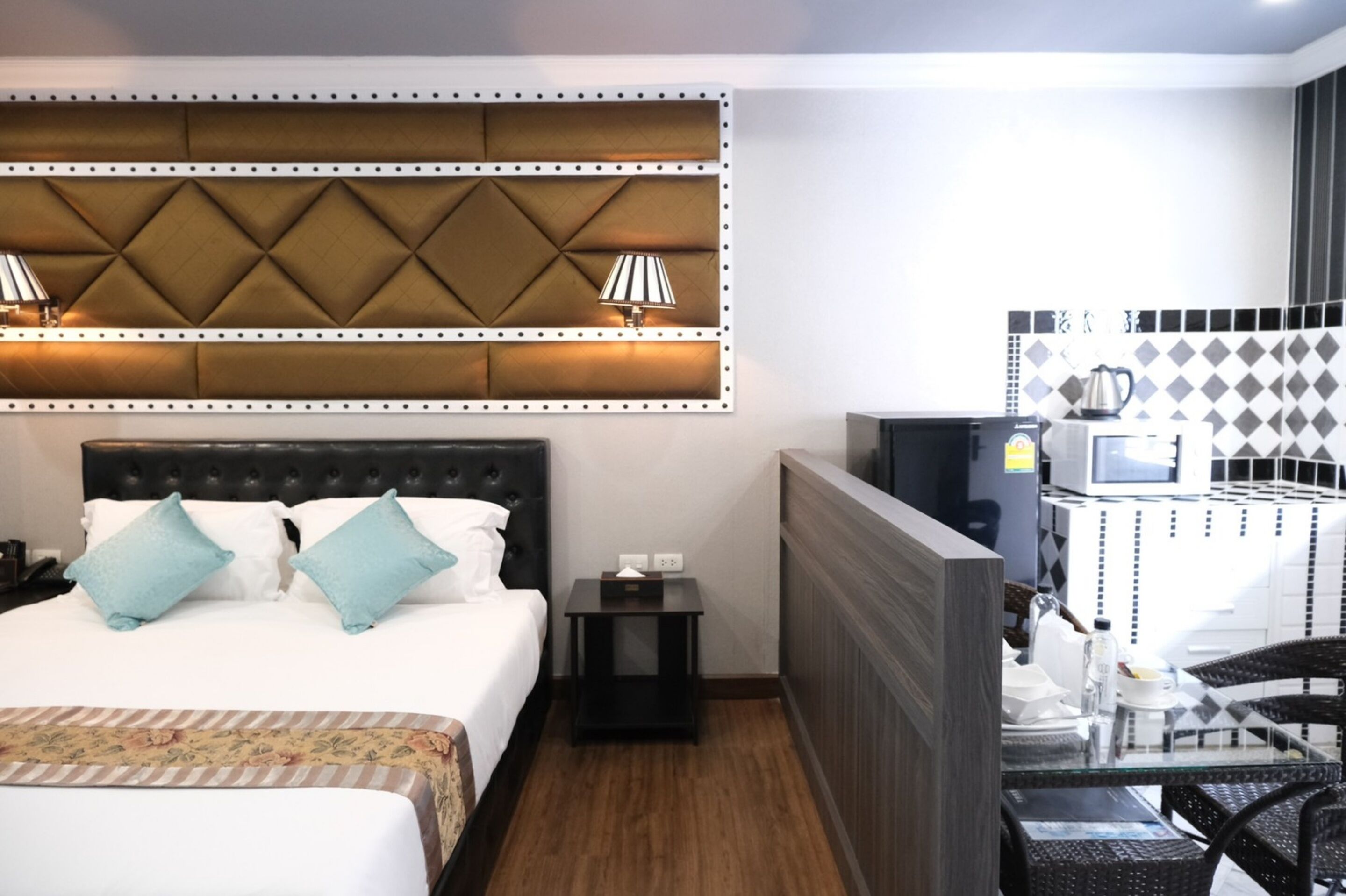Une chambre d’hôtel équipée d’un lit, de tables de chevet, d’un bureau avec une chaise, d’une télévision et d’un four à micro-ondes.