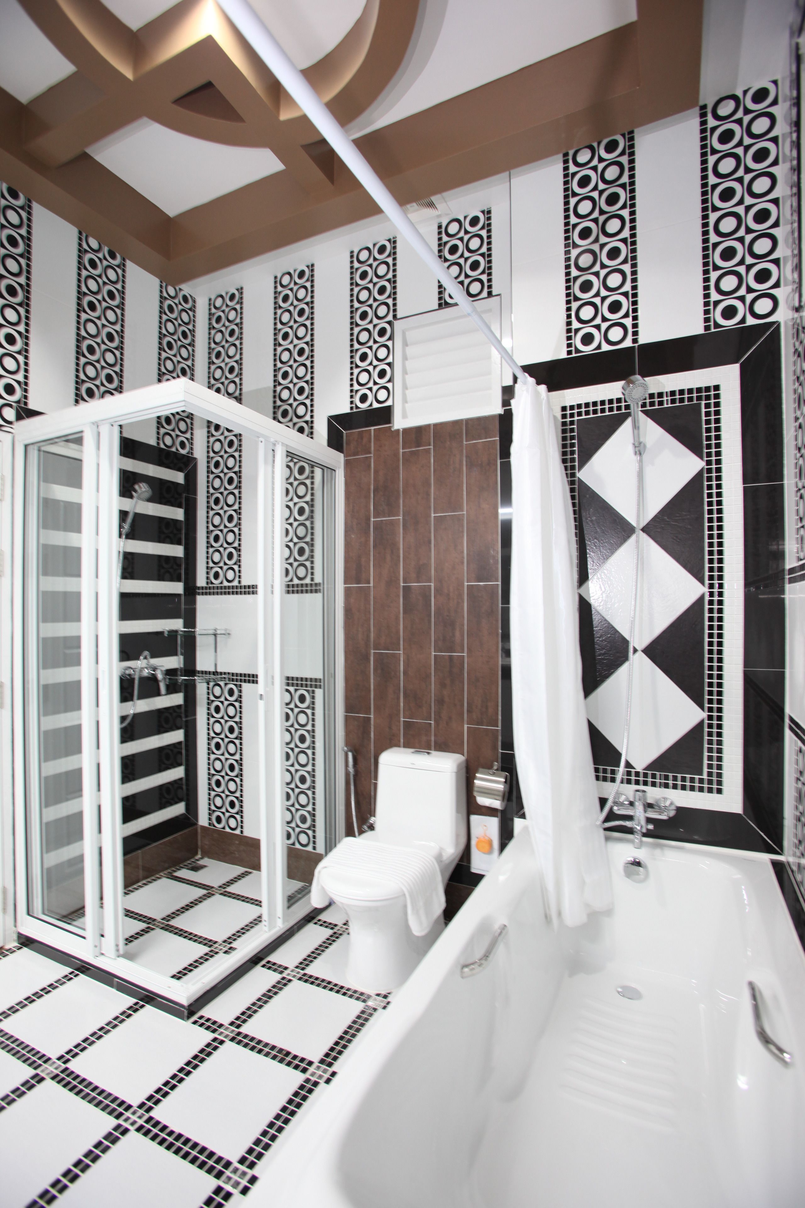 A modern bathroom with a walk-in shower, a bathtub, and a toilet.