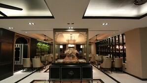 A hotel lobby with a checkered floor, a central reception desk, and seating areas. - KTK Pattaya Hotel and Residence (Pattaya)