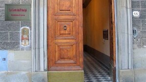 A wooden door with a plaque reading "La Corte dei Principi" and a sign above it.