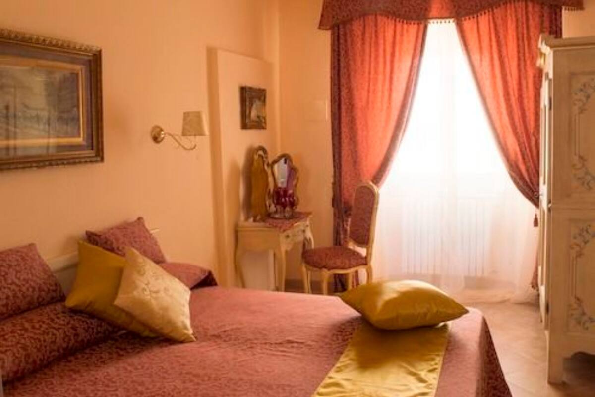 A bedroom with a bed, a chair, a desk, and a wardrobe.