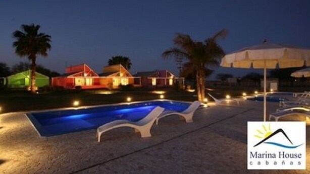 A marina with a swimming pool, lounge chairs, and a logo for 'Marina House cabanas'. - Cabañas Marina House (Termas de Rio Hondo)