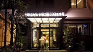 Ein Hotel mit gläserner Fassade und einem Schild über der Eingangstür.