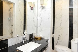 Un baño con un lavamanos blanco, encimera negra y un inodoro.