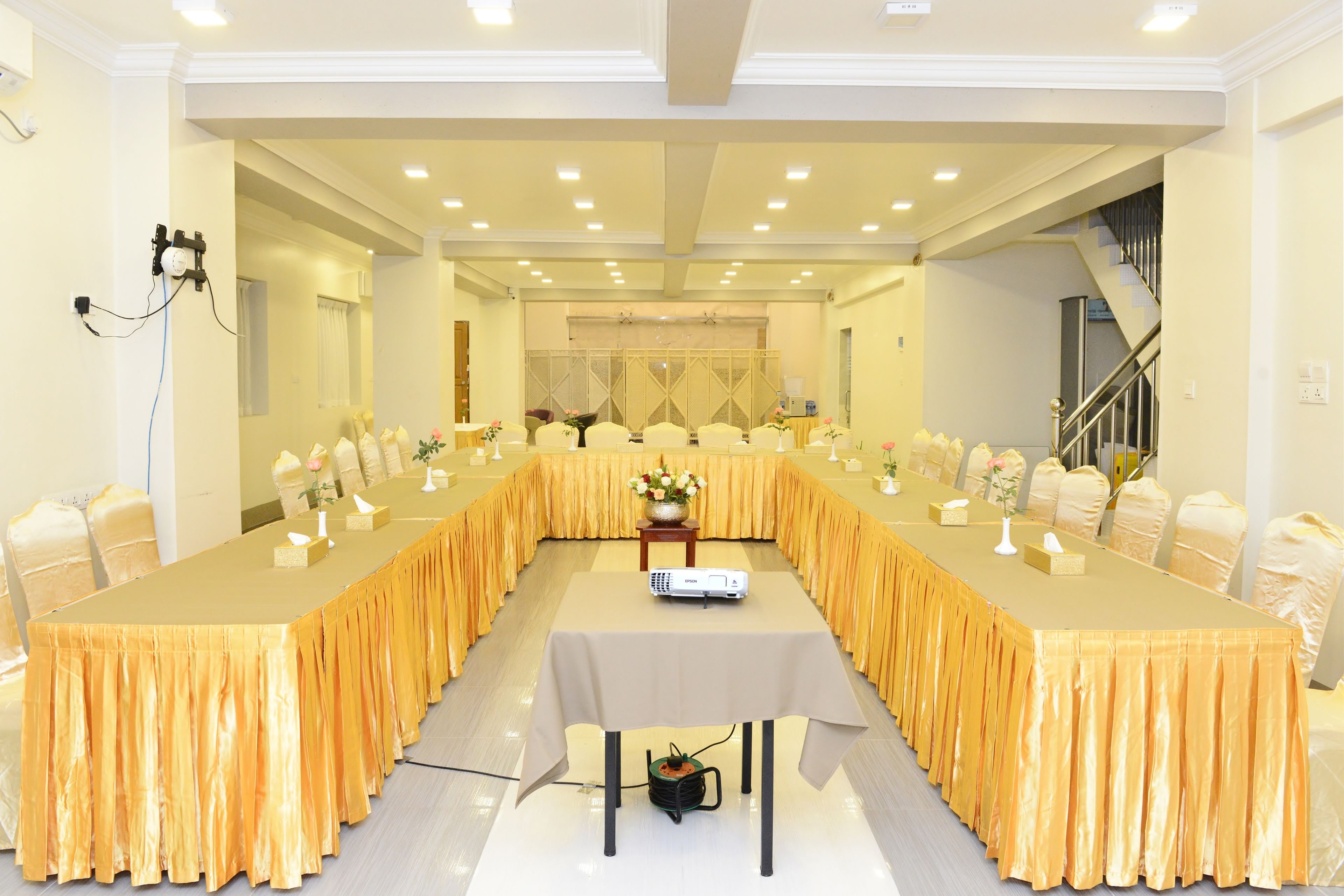 A conference room with a long table, chairs, and a projector.