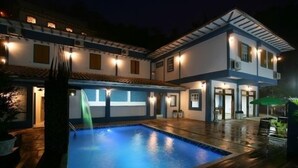 A two-story house with a swimming pool, outdoor lighting, and a covered patio area. - Hotel Solar das Lajes (Ouro Preto)