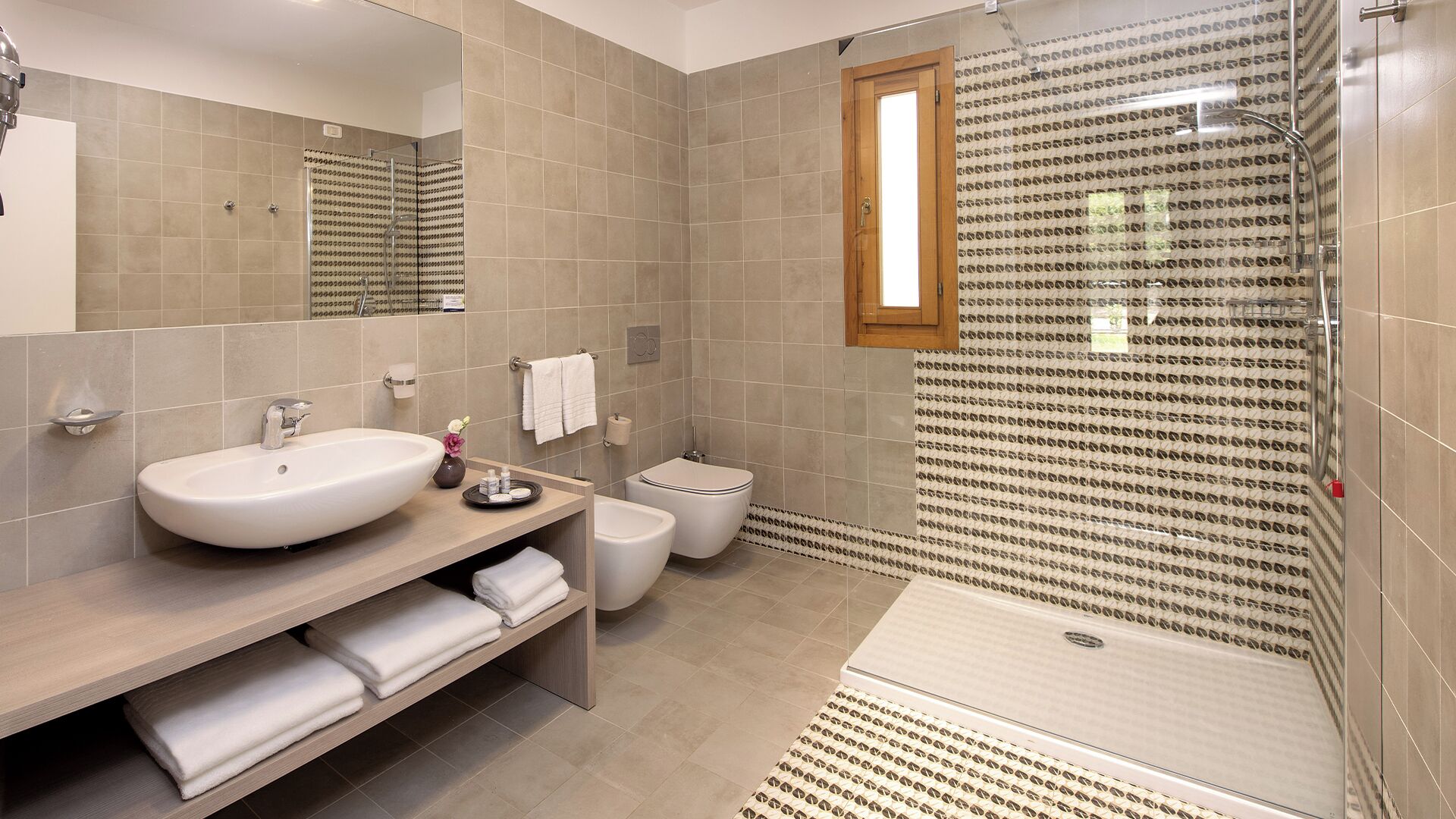 Un baño moderno con un lavabo grande, inodoro y zona de ducha.