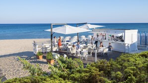 A beachside cafe with outdoor seating, white umbrellas, and a bar area. - Ethra Reserve - Valentino 4* (Castellaneta Marina)