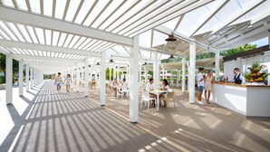 An outdoor covered patio area with tables and chairs, a food service counter, and a clear sky above. - Ethra Reserve - Valentino 4* (Castellaneta Marina)