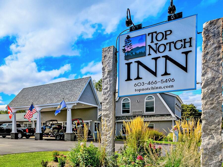 Señal para Top Notch Inn con un número de contacto y sitio web.