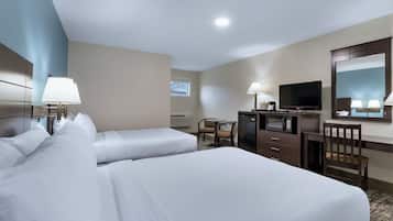 Une chambre d’hôtel avec deux lits, un bureau, une télévision et un miroir.