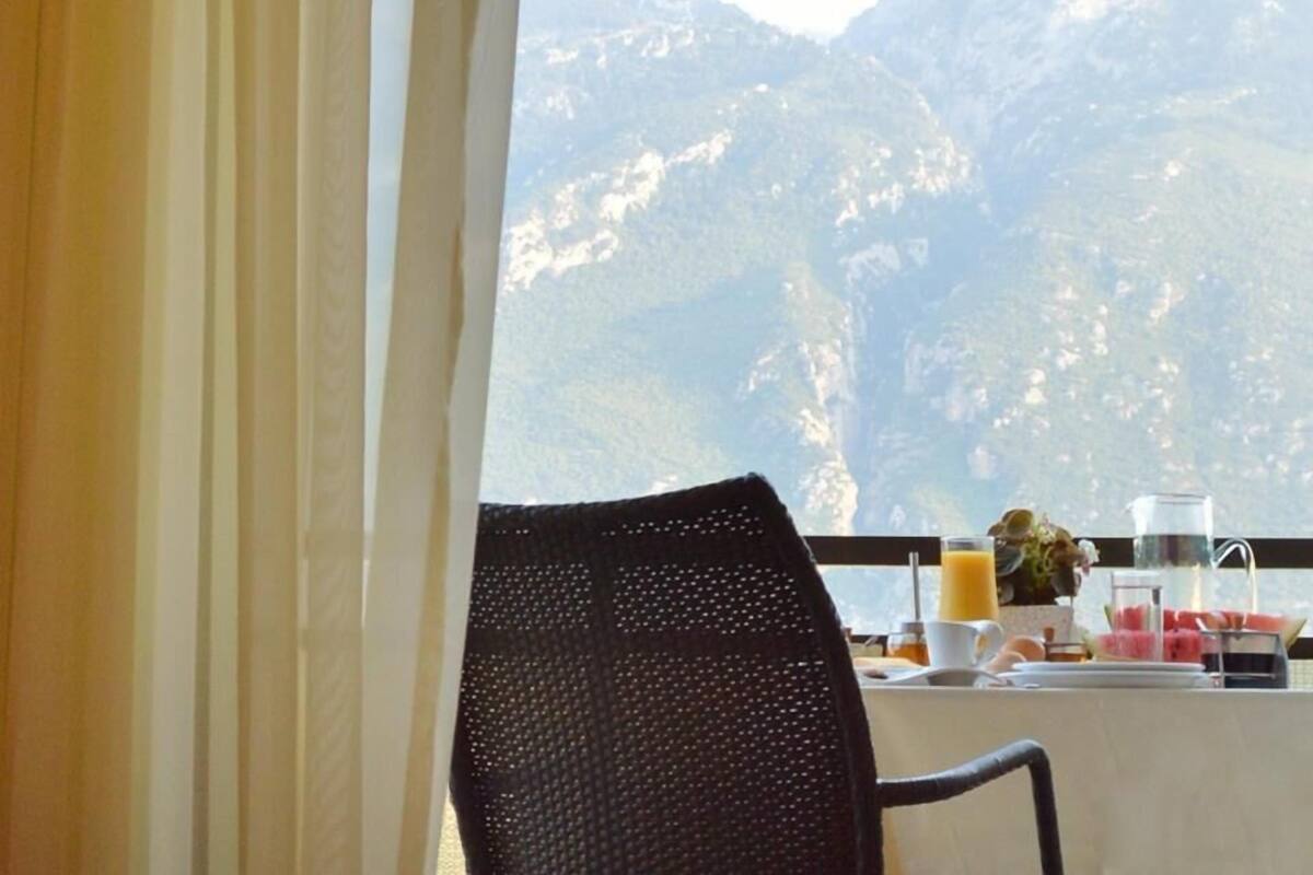 A dining area with a mountain view, a chair, and breakfast items on the table.