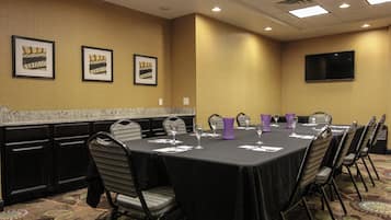 A conference room with a long table, chairs, and framed pictures on the wall.