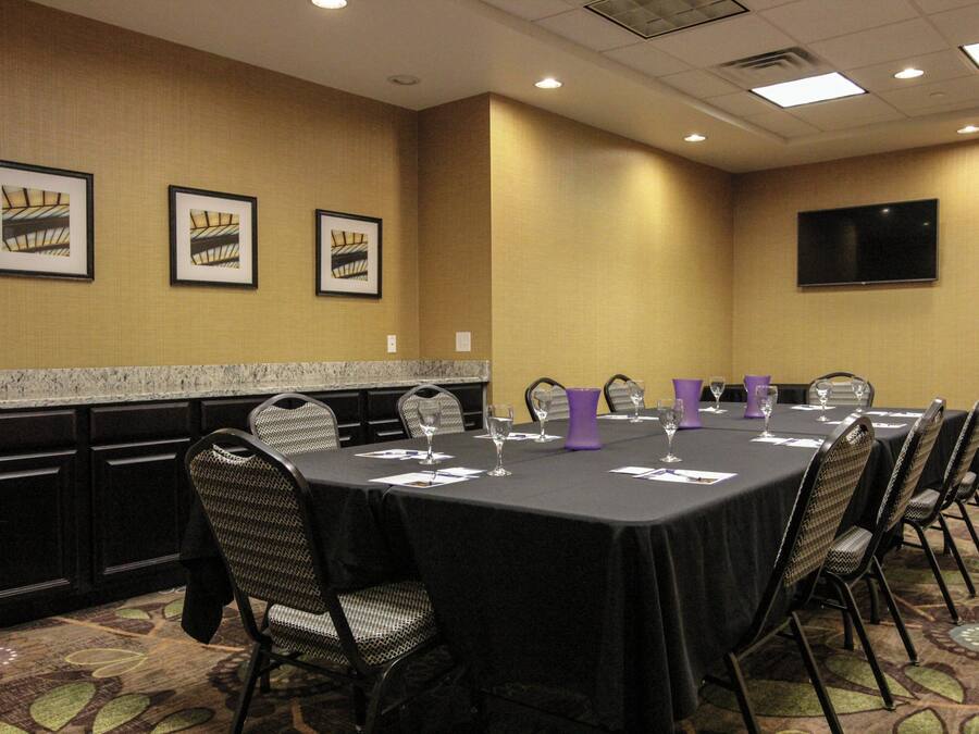 A conference room with a long table, chairs, and framed pictures on the wall.