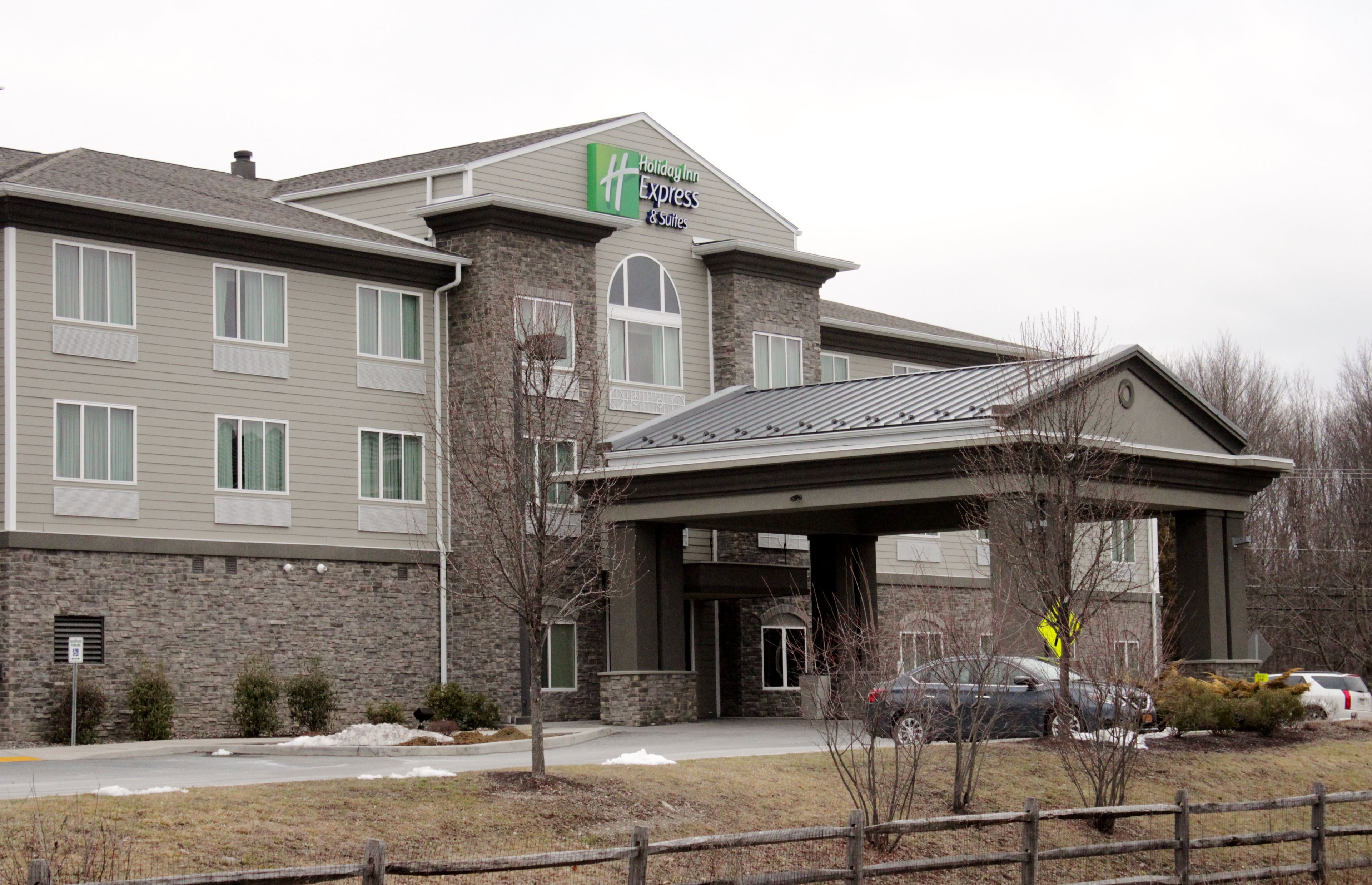 A Holiday Inn Express hotel with a stone facade, multiple windows, and a covered entrance.