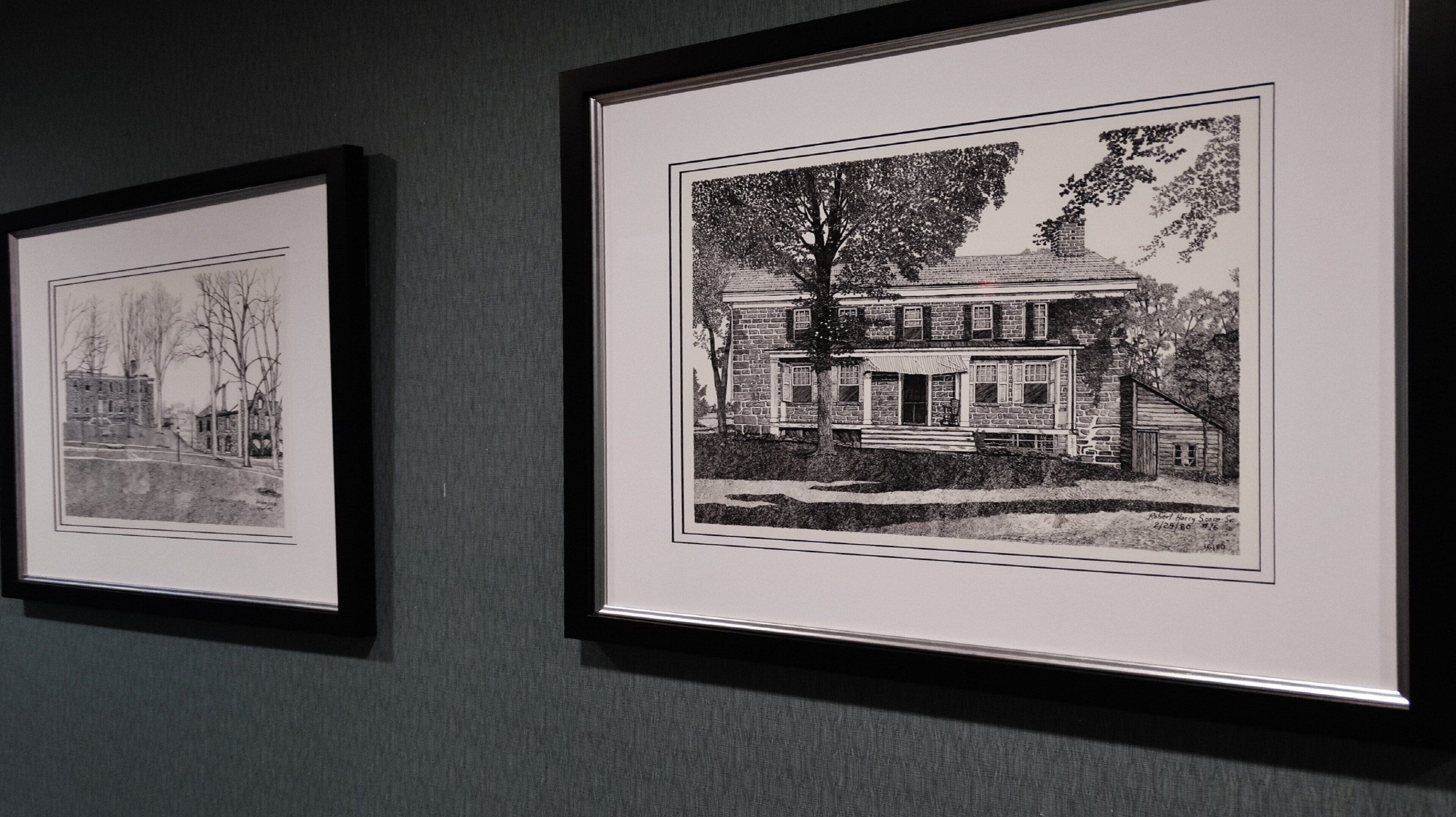 Two framed black and white architectural drawings on a wall.