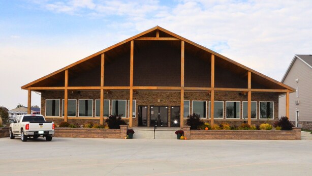 A building with a large entrance, multiple windows, and a brick facade.