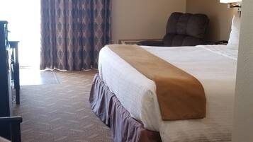 Una habitación de hotel con una cama grande, un escritorio y una silla.