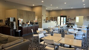 Un hall d’hôtel comprenant un comptoir d’accueil, un espace salon et un tapis à motifs.