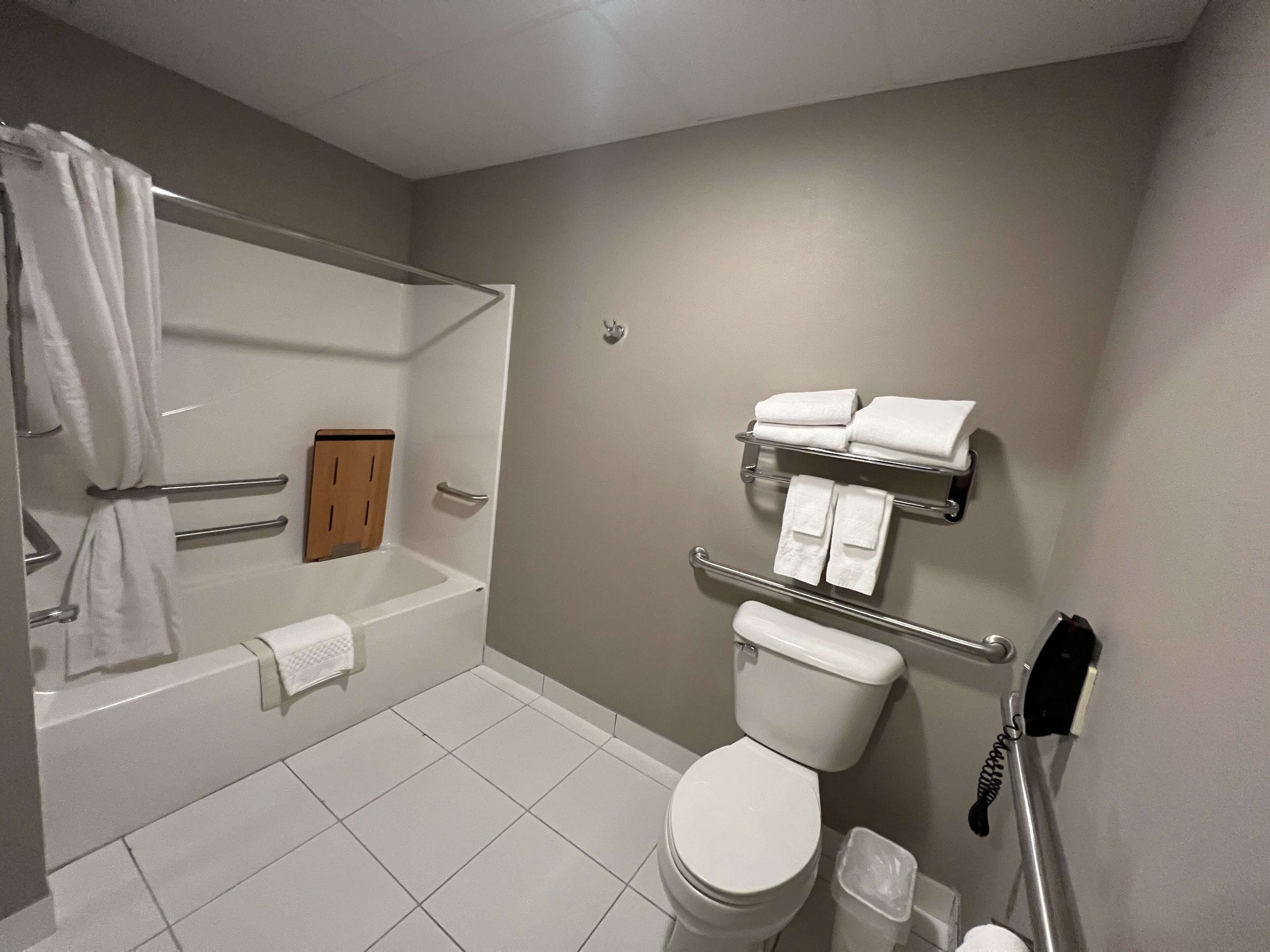 A bathroom with a bathtub, toilet, and a towel rack.