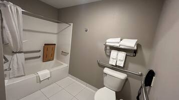 A bathroom with a bathtub, toilet, and a towel rack.