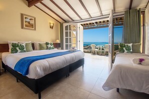 A hotel room with a bed, a smaller bed, a balcony with a view, and a painting on the wall. - Pousada e Spa Villa Mercedes by Latitud Hoteles (Búzios)